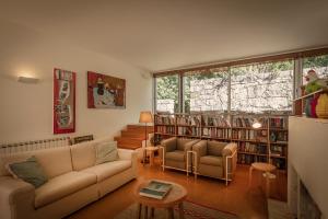 a living room with a couch and chairs and bookshelves at Casa de Pardelhas in Cima de Vila