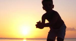 a young boy running on the beach at sunset at Jasmine & Tea House in Mae Nam