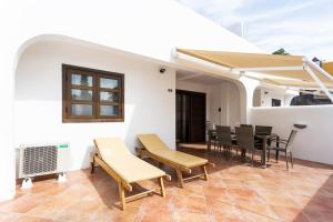 a patio with a table and chairs and an umbrella at Adeje Paradise Apartments in Adeje