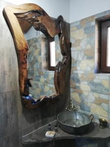a bathroom with a sink and a tree branch mirror at GUEST HOUSE ELENA in Kosovo +47 photos