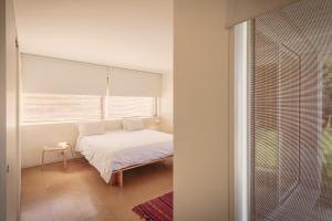 a white bedroom with a bed and a window at Casa de Pardelhas in Cima de Vila +47 photos
