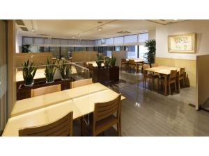 尾道市にあるOnomichi Kokusai Hotel - Vacation STAY 87042vの木製のテーブルと椅子、テーブル、植物のあるレストラン