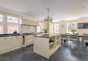 a large kitchen with white cabinets and a dining room at St Aidans in North Berwick