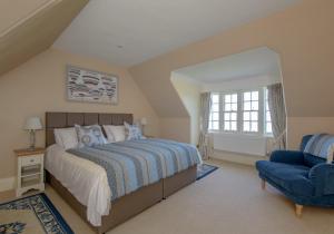 a bedroom with a bed and a blue chair at St Aidans in North Berwick