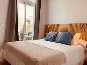 sypialnia z dużym łóżkiem i niebieskimi poduszkami w obiekcie Cozy apartments and deluxe lofts in Fuerteventura w mieście Cotillo