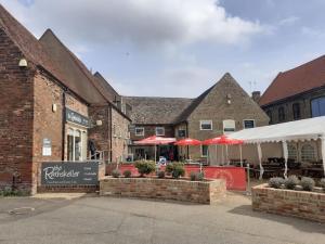 a brick building with red umbrellas in front of it at The Vault - boutique apartment in the centre of King's Lynn in Kings Lynn