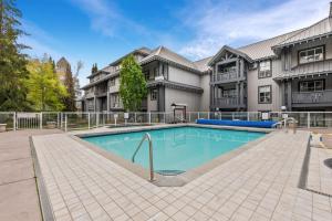 a swimming pool in front of a building at Modern Studio at Blackcomb base in Whistler