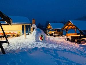 a small igloo in the snow at night at Pensiunea Dorali in Moieciu de Jos