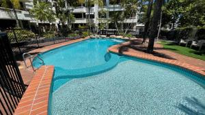a large swimming pool in a yard with a building at Headland Gardens Holiday Apartments in Alexandra Headland