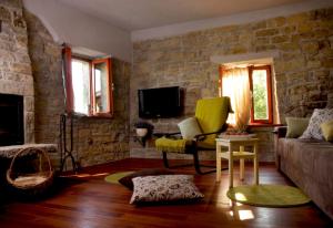 - un salon avec un canapé et un mur en pierre dans l'établissement Apartman CASA MARŠIĆ, à Oprtalj