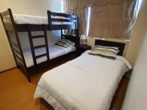 a bedroom with two bunk beds and a window at Hotel Capelli Express in Talca