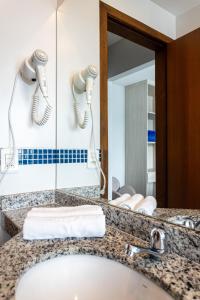 a bathroom with a sink and a mirror at Pousada Casa da Praia Angra in Angra dos Reis