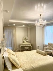 a bedroom with a large bed and a chandelier at Sofievsky Posad Hotel in Kyiv