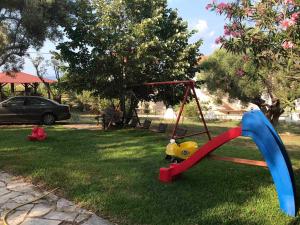 a swing set in the grass with a car in the background at Vila Vergina in Pefkochori