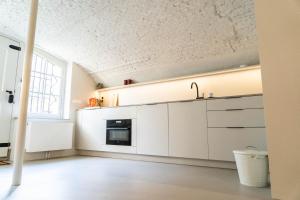 a kitchen with white cabinets and a ceiling at Vlinder's in Utrecht