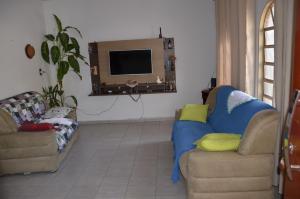 sala de estar con 2 sofás y TV en NinhoFeliz, en Caldas Novas