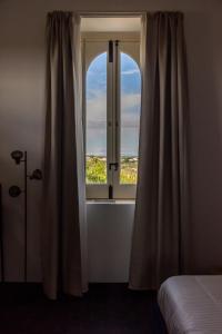 a bedroom with a window with a view at Chiusa del Curiale - ospitalità in vigna in Comiso