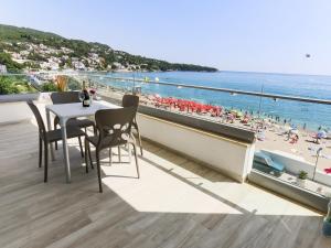 balcone con tavolo, sedie e spiaggia di Apart Hotel Sea Fort a Sutomore