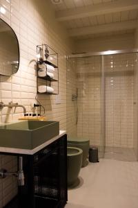 baño con lavabo verde y aseo en Chiusa del Curiale - ospitalità in vigna, en Comiso