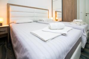 um quarto com 2 camas e toalhas em Apartments Limunada em Utjeha