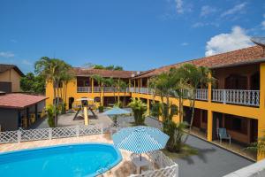 a view of a resort with a swimming pool and patio at Chalés Pajuçara in Ubatuba