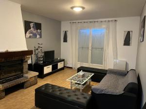 a living room with a couch and a fireplace at Maison proche de l'aéroport CDG-Paris in Goussainville