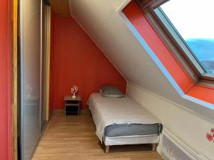 un piccolo letto in una stanza con una finestra di Maison proche de l'aéroport CDG-Paris a Goussainville