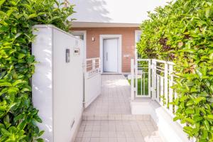 une passerelle avec une haie devant une maison dans l'établissement Appartamento Scirocco, à Riccione