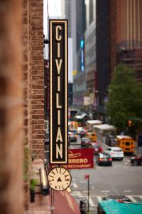 a sign on a building with a clock on a city street at CIVILIAN Hotel in New York