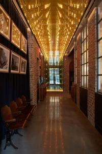 a hallway with chairs and lights on the ceiling at CIVILIAN Hotel in New York