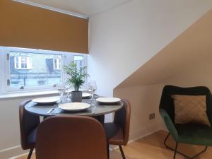een eetkamer met een tafel en stoelen en een raam bij Crown Central Apartments in Aberdeen