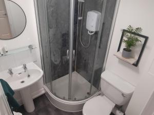 een badkamer met een douche, een toilet en een wastafel bij Crown Central Apartments in Aberdeen