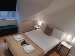 a bedroom with a large white bed with shoes on it at Crown Central Apartments in Aberdeen +17 photos