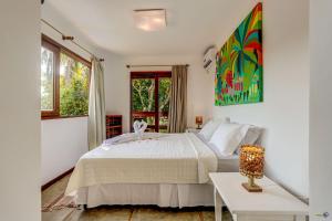 um quarto com uma cama branca e uma mesa em Pousada Vila Galea em Itacaré
