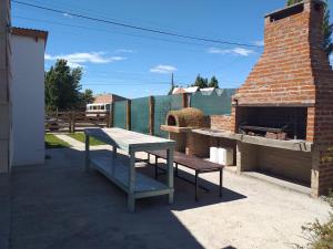 uma mesa e um banco em frente a um forno de tijolos em FTE LAGO ARGENTINO em El Calafate