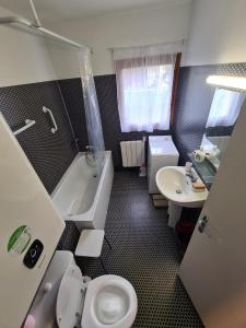 Très joli appartement 4-6 personnes dans Luchon في لوشون: حمام مع مرحاض وحوض استحمام ومغسلة