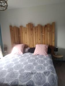 um quarto com uma cama grande e uma cabeceira em madeira em Virginie et Serge em Fuissé
