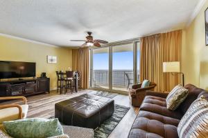 a living room with a couch and a flat screen tv at Emerald Beach #1227 by Book That Condo in Panama City Beach