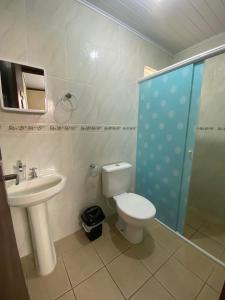 Un baño con inodoro, lavabo y ducha. en Casa entre dois mares - Casa Bege, en Bombinhas