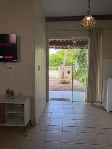 una sala de estar con una puerta corredera de cristal que da a un patio en Casa entre dois mares - Casa Bege, en Bombinhas