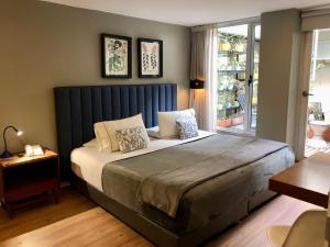 a bedroom with a large bed with a blue headboard at Hotel Living 55 in Bogotá