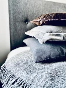 a pile of pillows sitting on top of a bed at Cesis Boulevard Apartments in Cēsis