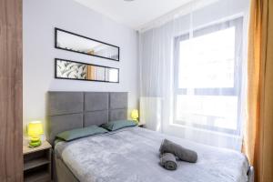 a bedroom with a large bed with a large window at Dąbska Street Krakow - Luxury Apartments in Krakow