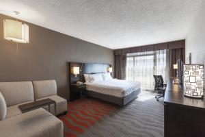 ein Hotelzimmer mit einem Bett, einem Schreibtisch und einem Sofa in der Unterkunft Holiday Inn Austin Midtown, an IHG Hotel in Austin