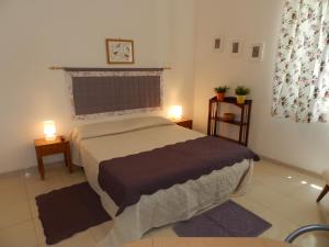 1 dormitorio con 1 cama y 2 luces en 2 mesas en Orleans Apartments, en Palermo