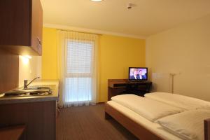 a bedroom with a bed and a television in it at Fair-Price-Hotel in Bad Waltersdorf