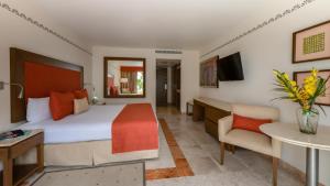 a hotel room with a large bed and a desk at Grand Park Royal Cancun in Cancún