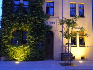 ein mit Efeu bedecktes Gebäude mit einer Tür und einem Baum in der Unterkunft Pension La rose in Brandenburg an der Havel