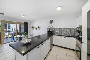 a kitchen with a sink, stove, and counter top at Paradis Pacifique in Maroochydore