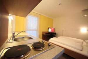 a kitchen with a sink and a bed in a room at Fair-Price-Hotel in Bad Waltersdorf